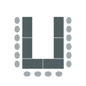 Tables arranged in horseshoe shape with open end facing front of room and chairs around outside edges
