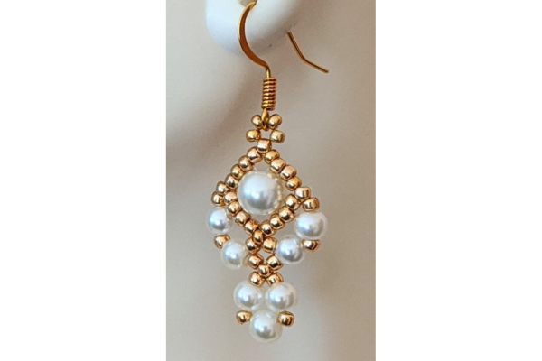 Hanging  gold and white teardrop earring.