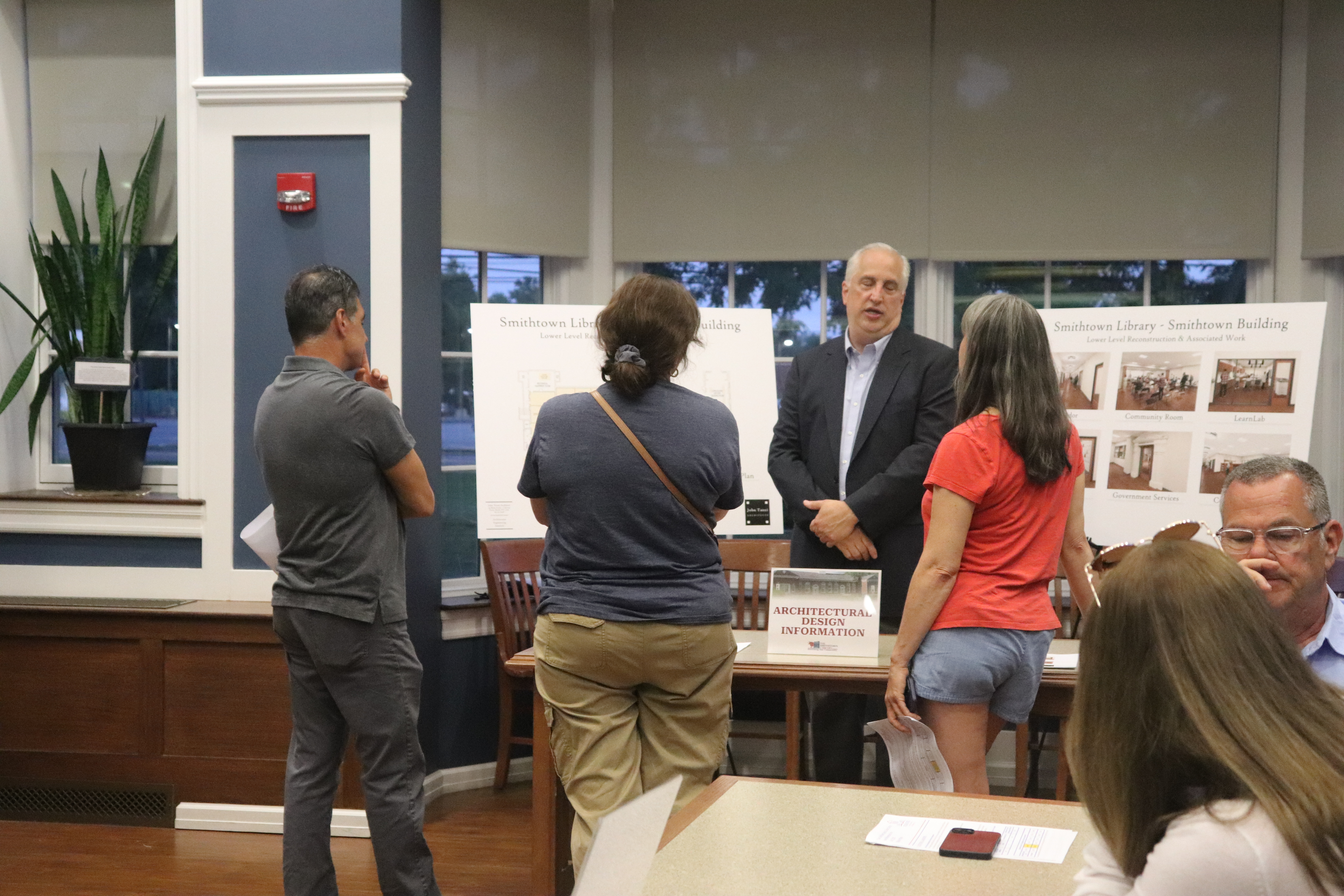 group of people standing look at plans