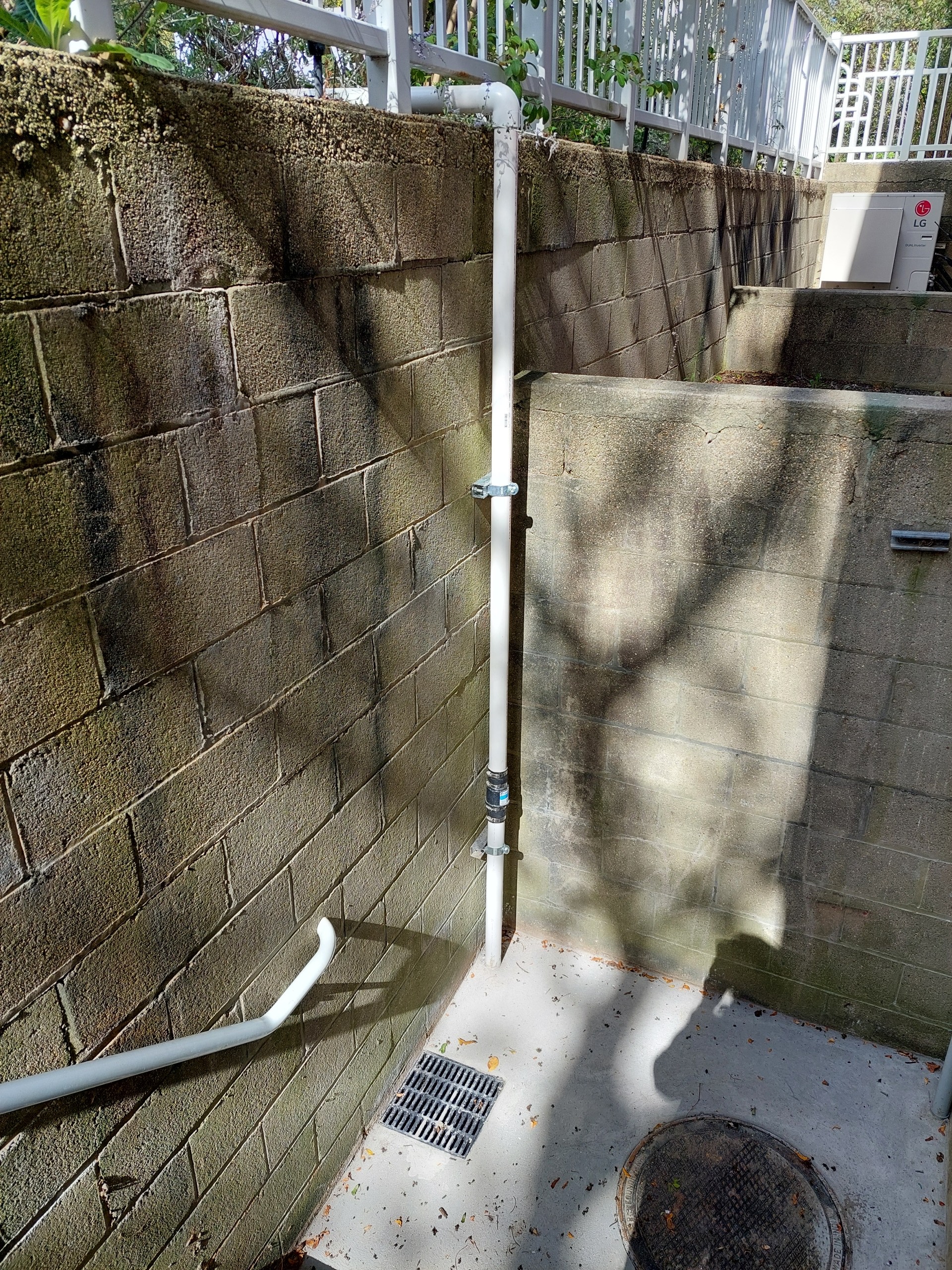 drainage area on the east side of the building surrounded by cinderblock 