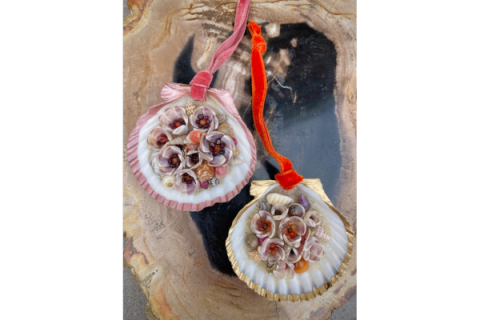 ornate scallop seashell hanging from a ribbon.