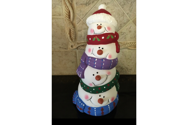 tower of ceramic snowman heads with hats and scarves.